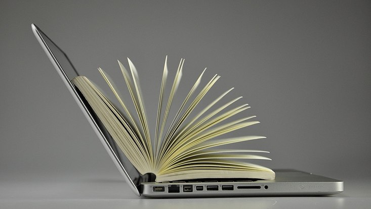 Laptop mit offenem Buch