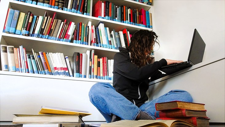 Studierende in einem Berg von Büchern