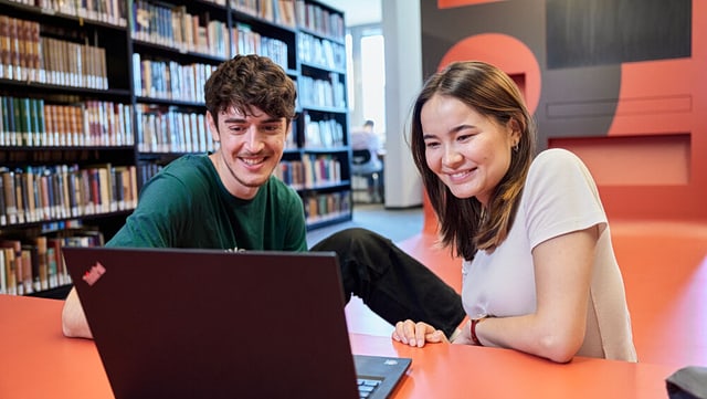 Studierende vorm Laptop am Infopoint